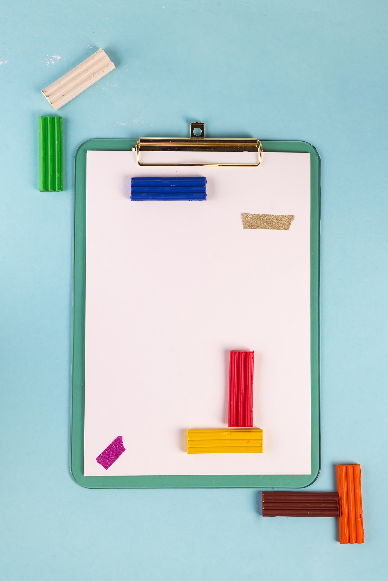 Flat lay blue clipboard with plasticine on a blue background. Frame mockup with copy space for text